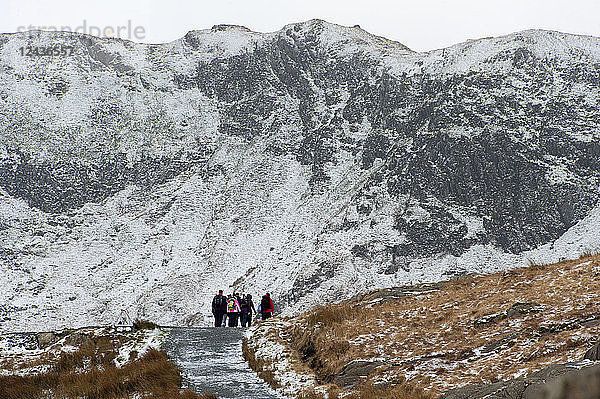 Wanderer auf dem Miner's Track am Fuß des Mount Snowdon in einer winterlichen Landschaft im Snowdonia National Park  Gwynedd  Wales  Vereinigtes Königreich  Europa
