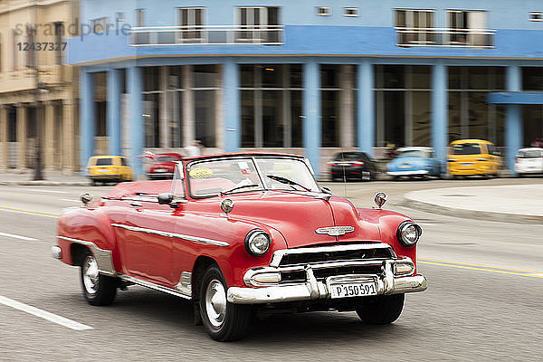 Ein rotes amerikanisches Cabrio-Oldtimer-Auto auf dem Malecon in Havanna  Kuba  Westindien  Karibik  Mittelamerika
