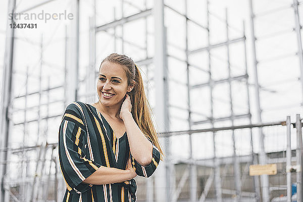 Portrait of smiling young woman at scaffolding