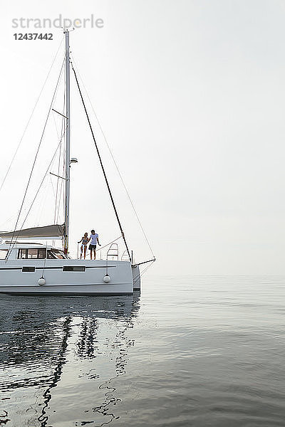 Couple setting off for a sailing trip on a catamaran