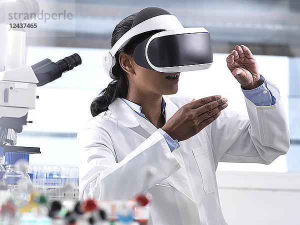 Female scientist using virtual reality to understand a research experiment in the laboratory