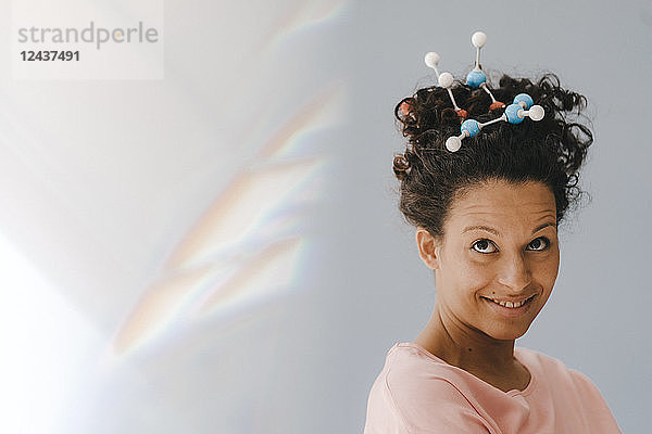 Young woman with molecule model in her hair