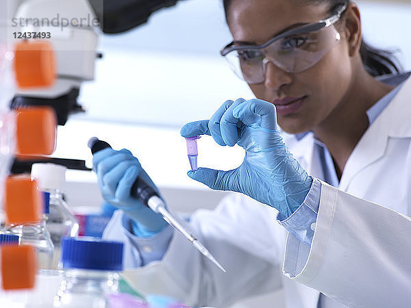 Genetic research  female scientist viewing sample in a eppendorf vial  analysis in the laboratory