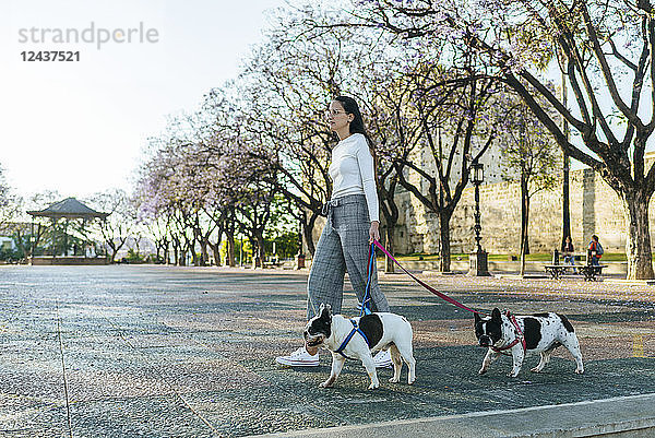 Spain  Andalusia  Jerez de la Frontera  Woman walking with two dogs on square
