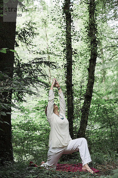 Senior woman doing yoga in the forest