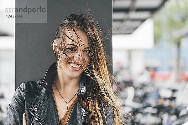 Portrait of happy young woman with windswept hair