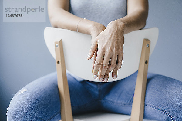Hands of a woman sitting on a chair