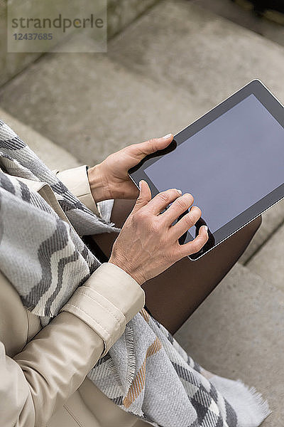 Woman using digital tablet  partial view