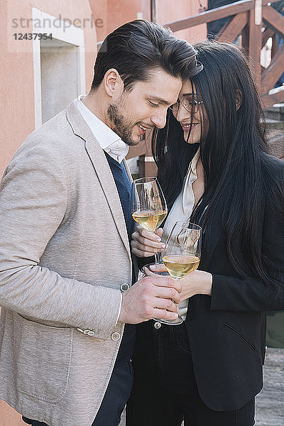 Elegant affectionate couple drinking wine in the city