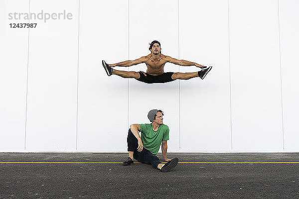 Two acrobats doing tricks together  jumping mid-air