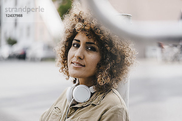 Woman in the city with headphones  portrait