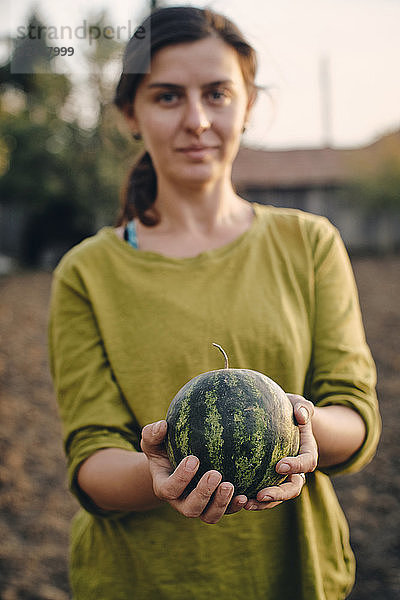 Bulgaria  Razgrad  woman holding small watermelon in garden
