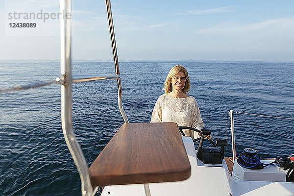 Mature woman navigating catamaran on a sailing trip