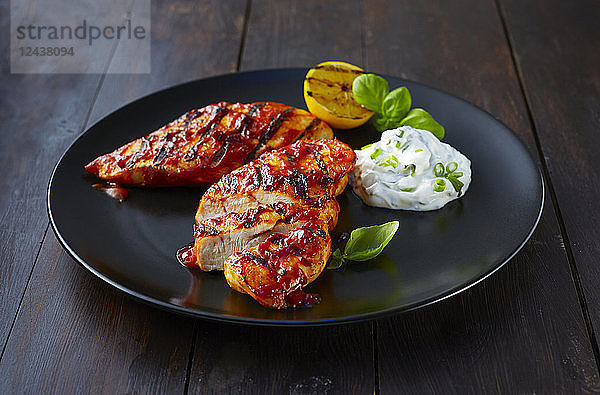 Grilled chicken breast fillet with sour cream on plate