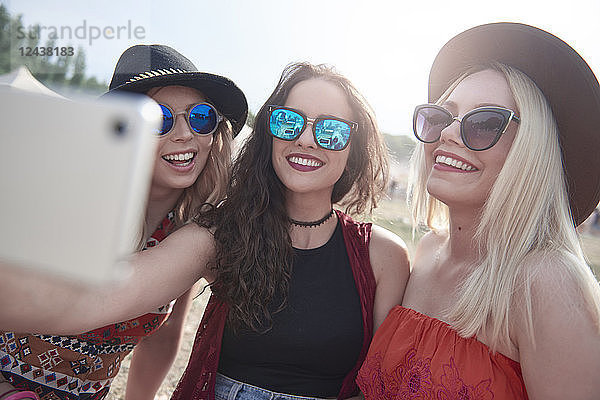Happy friends taking a selfie at music festival