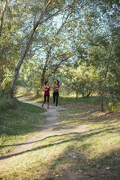 Two active women running in forest