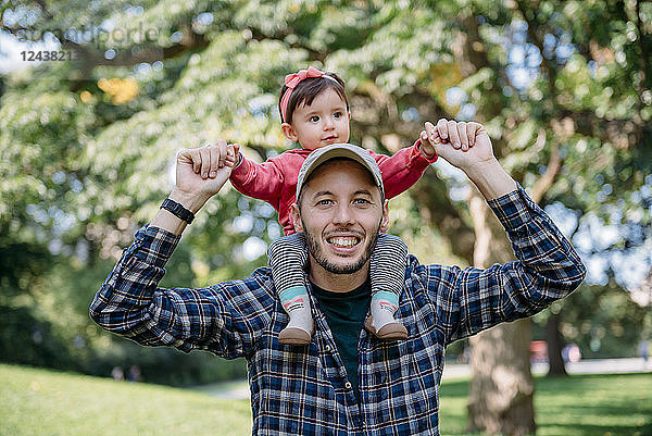 USA  New York  Father with baby girl on his shoulders walking through Central Park