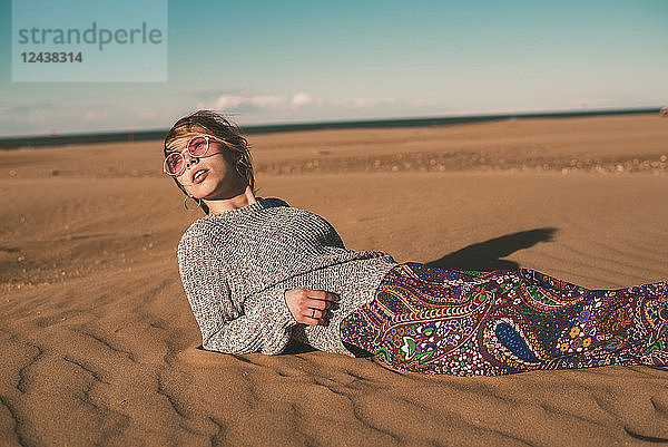 Spain  fashionable young woman wearing sunglasses lying on the beach
