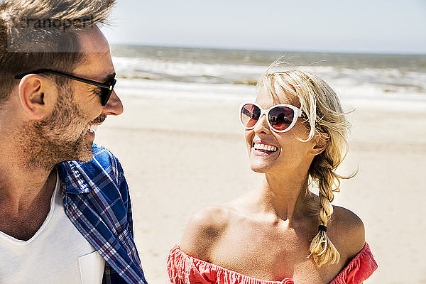 Happy couple wearing sunglasses on the beach