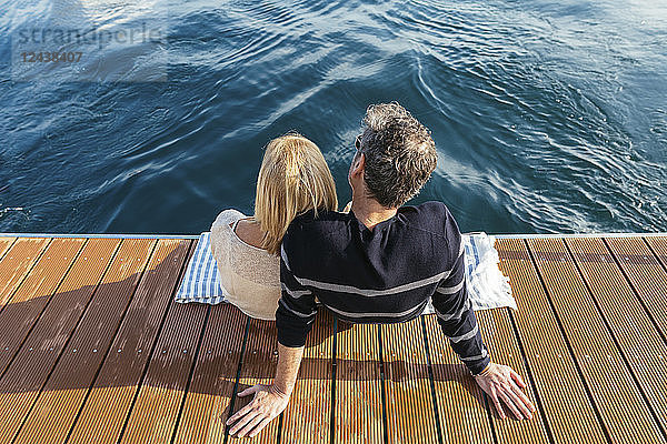 Mature couple sitting on jetty  relaxing at the sea