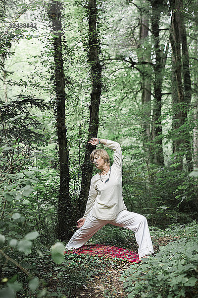 Senior woman doing yoga in the forest