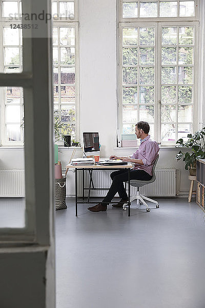 Man working at desk in a loft office
