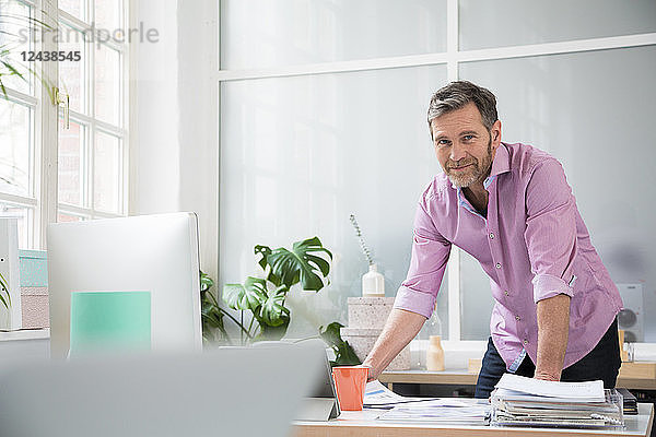 Portrait of a man working at desk in office