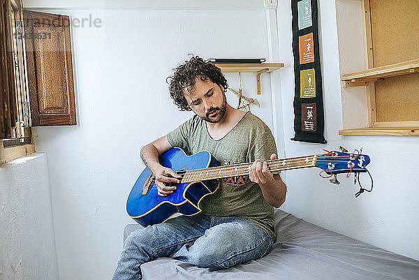 Spain  Man playing bass guitar in his room