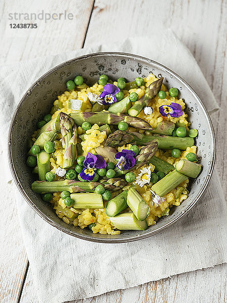 Risotto with green asparagus and peas  garnished with edible flowers