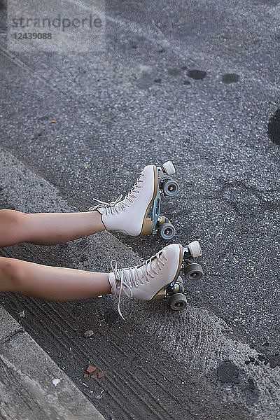 Young woman with roller skates on lane  partial view