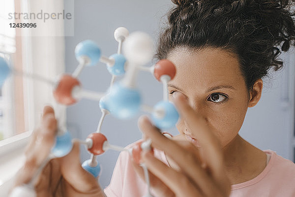 Female scientist holding molecule model  looking for solutions