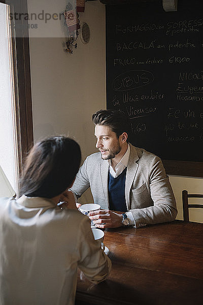 Elegant couple talking in a cafe