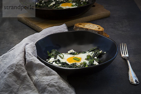 Bowl of green Shakshouka with baby spinat  chard  spring onions and basil