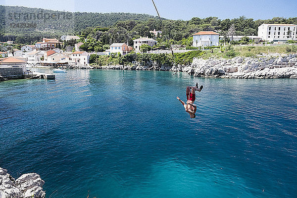Croatia  Istria  Losinj  Rovenska  Young man bungee jumping