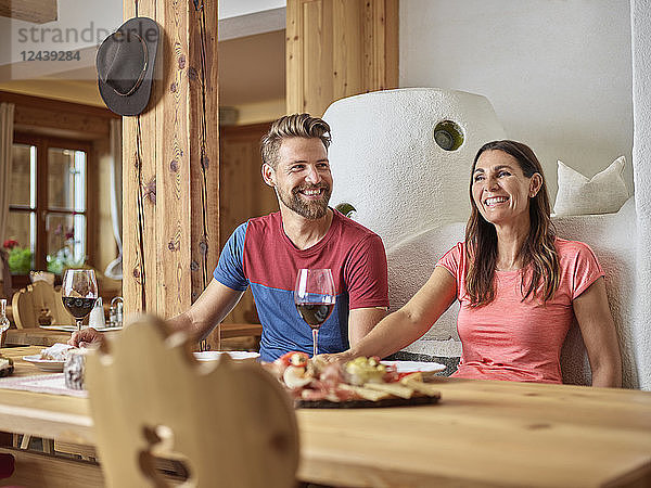 Happy couple having a snack in an alpine cabin