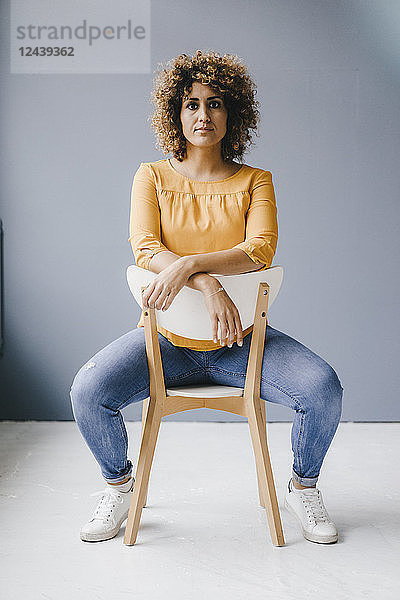 Woman sitting on chair  looking determined