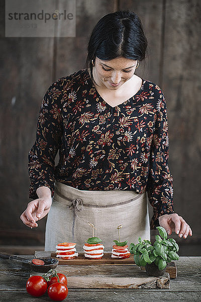 Woman preparing Caprese Salad