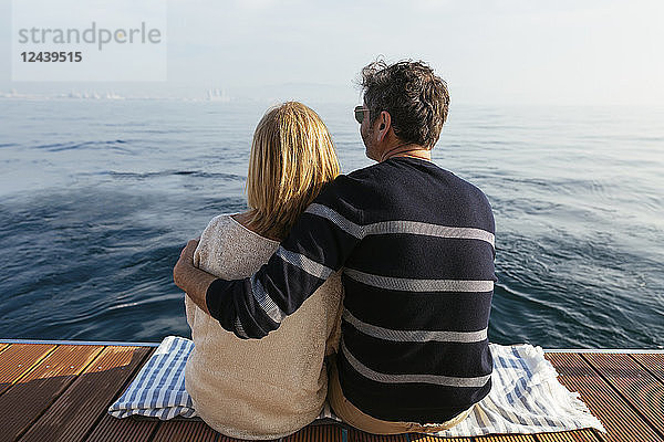 Mature couple sitting on jetty  relaxing at the sea