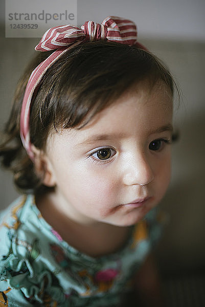 Portrait of concentrated baby girl at home