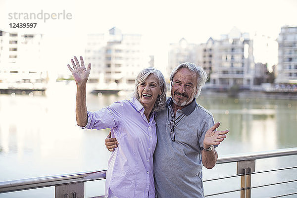 Senior couple taking a city break  having fun  waving