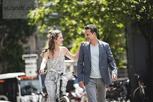 Happy couple with bicycle in the city