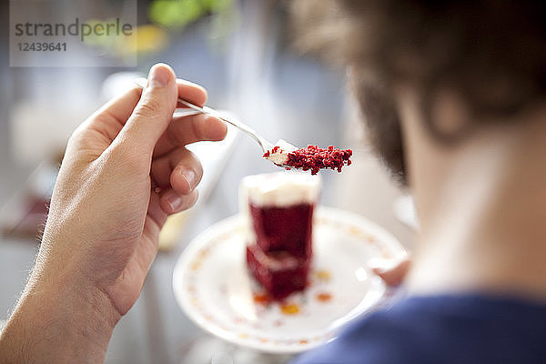 Young man eating fancy cake  close-up