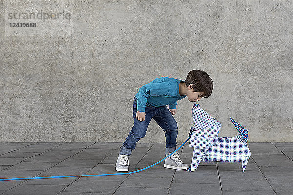 Little boy kissing origami dog