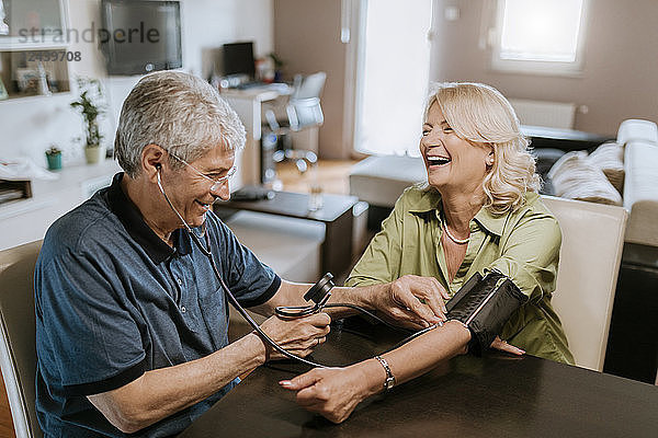 Happy senior couple taking blood pressure