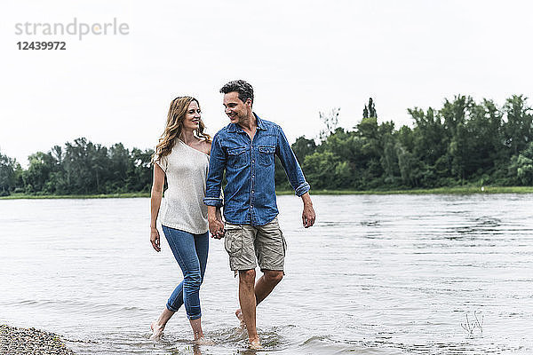 Smiling couple wading in river