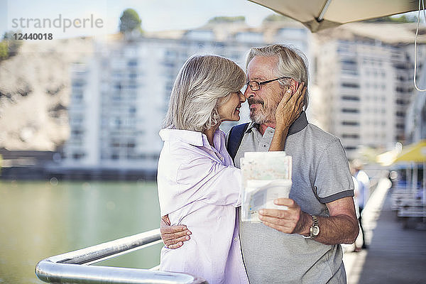 Senior couple taking a city break  holding map