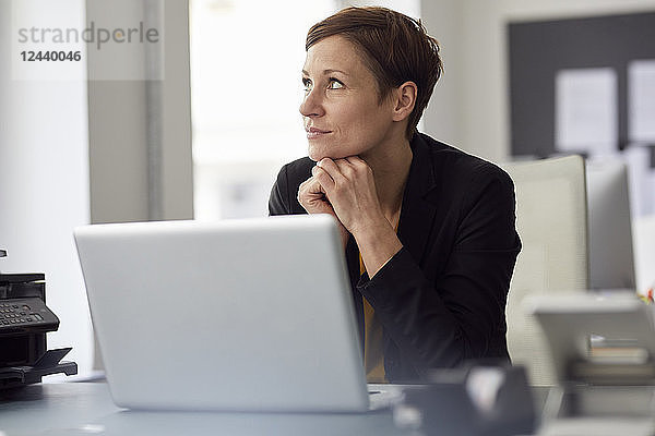 Businesswoman sitting in office  using laptop