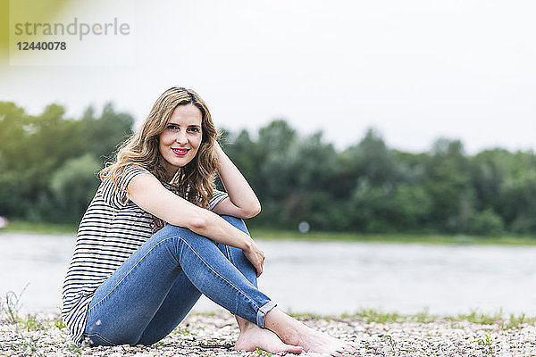 Portrait of smiling woman sitting at the riverside