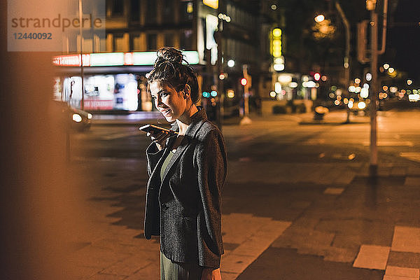 Young businesswoman on the phone at night