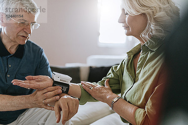 Senior couple taking blood pressure at home